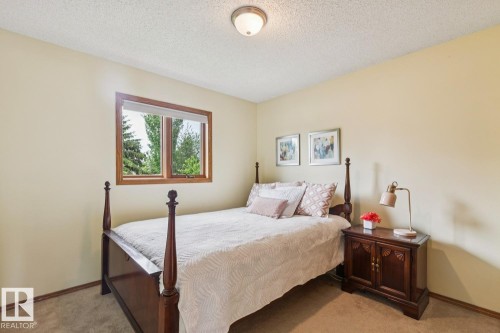 Room featuring a wood-trimmed window with a roller shade, light-toned walls, and textured ceiling - 15804 80 Street, Edmonton, AB 