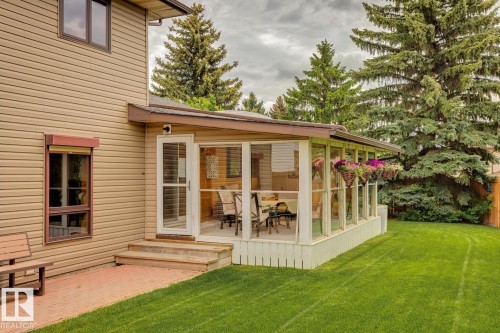 Sunroom addition with glass panels and a screened door opening onto a brick-paved patio - 15804 80 Street, Edmonton, AB 