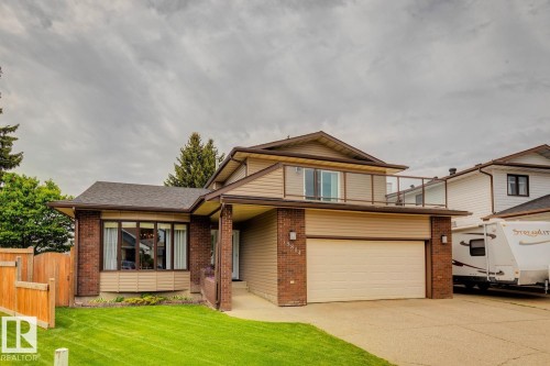 Two-story residence featuring a brick and siding exterior, an attached garage, and a second-story balcony with a glass railing - 15804 80 Street, Edmonton, AB 