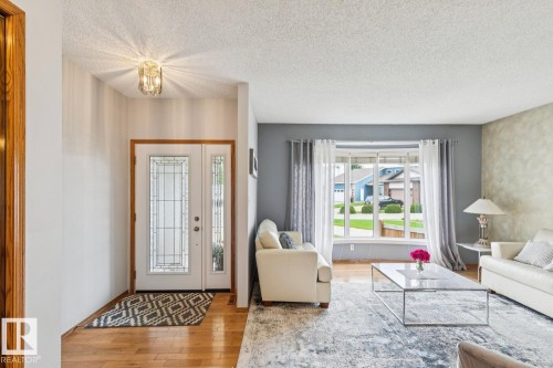 Entryway with a double door featuring decorative glass inserts and wood-finish flooring - 15804 80 Street, Edmonton, AB 