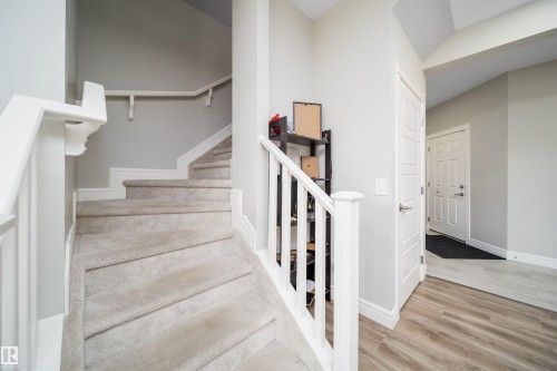 Carpeted staircase with white balusters and handrail, leading to an upper level - 16123 31 Avenue, Edmonton, AB 