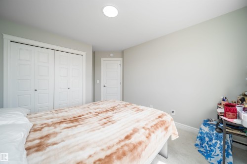 Recessed ceiling light fixture illuminating a spacious room with light-toned walls and carpet - 16123 31 Avenue, Edmonton, AB 