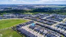 Aerial overview showcasing a residential development with numerous single-family homes, bordered by open green spaces and mature trees - 16123 31 Avenue, Edmonton, AB 