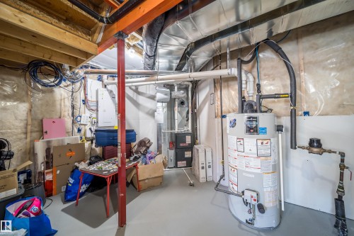 Unfinished basement featuring exposed wood joists, a water heater, a furnace, and visible ductwork - 16123 31 Avenue, Edmonton, AB 