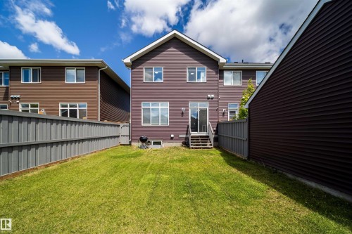 Rear exterior with full-height vinyl siding, ground-level green space, and privacy fencing - 16123 31 Avenue, Edmonton, AB 