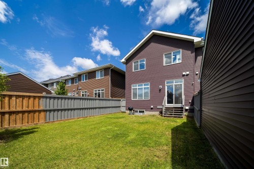 Expansive backyard featuring a green lawn, wood and composite fencing, and a two-story home with brown siding - 16123 31 Avenue, Edmonton, AB 