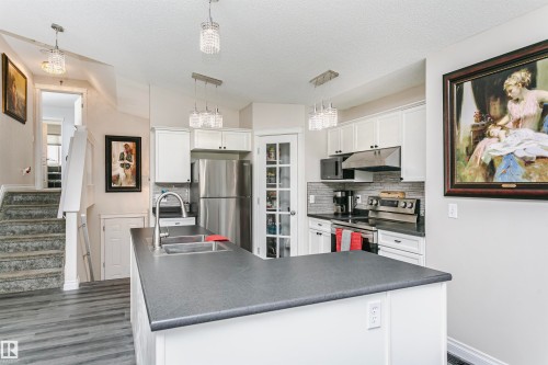 Kitchen featuring white cabinetry with dark hardware and a gray countertop - 4228 162 Avenue, Edmonton, AB 