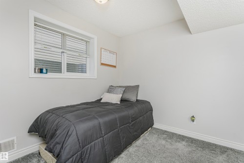 Room featuring light gray walls, gray carpet flooring, a white-framed window with blinds, a white ceiling, and white baseboards - 4228 162 Avenue, Edmonton, AB 