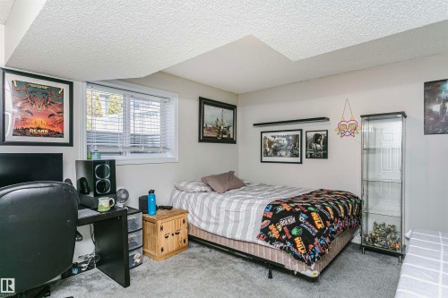 Neutral wall color with textured ceiling, featuring a window with horizontal blinds, and grey carpet flooring - 4228 162 Avenue, Edmonton, AB 