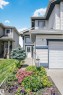 Siding exterior with contrasting trim, integrated garage, and a manicured front garden with diverse plantings - 4228 162 Avenue, Edmonton, AB 