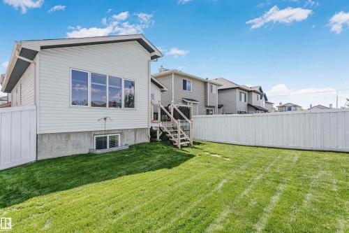Expansive backyard with a manicured lawn, full privacy fencing, and a multi-level wood deck - 4228 162 Avenue, Edmonton, AB 