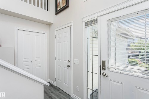 Entryway featuring wood-finish flooring, a white paneled door with a sidelight, and a second paneled door - 4228 162 Avenue, Edmonton, AB 