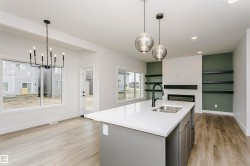 Central kitchen island with white countertop and integrated sink, complemented by two pendant lights - 