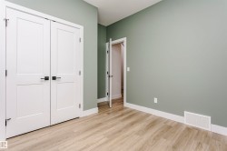 Room featuring light wood-finish flooring, light green painted walls, and white baseboards - 