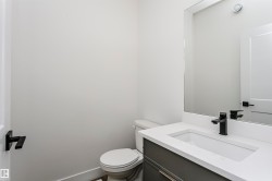 Bathroom vanity featuring a matte black faucet, undermount sink, and a light-toned countertop - 