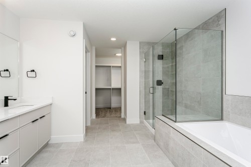 Contemporary bathroom featuring a spacious vanity with white countertop and matte black fixtures - 6210 Dansereau Crescent, Beaumont, AB 