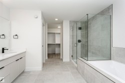Contemporary bathroom featuring a spacious vanity with white countertop and matte black fixtures - 