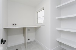 Dedicated laundry area featuring a white countertop, plumbing hookups, and a window for natural light - 