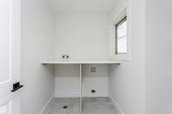 Utility room featuring a white countertop with integrated plumbing hookups, a single window, and a light gray tile floor - 