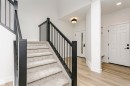 Carpeted staircase featuring black railings and newel posts - 6210 Dansereau Crescent, Beaumont, AB 