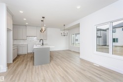 Modern kitchen and living area featuring light wood-finish flooring - 