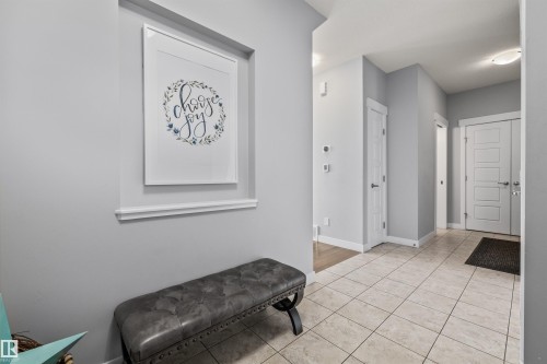 Entryway featuring light-toned tile flooring, light gray wall paint, white baseboards, and white interior doors with contemporary hardware - 607 40 Street, Edmonton, AB 