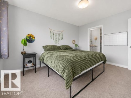 Carpeted bedroom featuring light gray walls and a ceiling-mounted flush light fixture - 607 40 Street, Edmonton, AB 