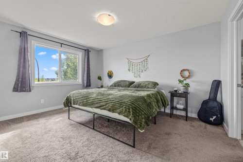 Bedroom featuring a double-pane window, neutral-toned carpeting, and light gray wall paint - 607 40 Street, Edmonton, AB 