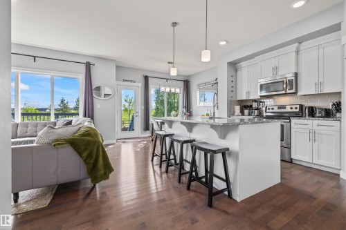 Open-concept living space with dark wood-finish flooring - 607 40 Street, Edmonton, AB 