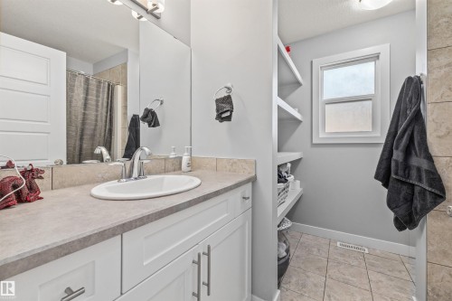 Bathroom featuring a white vanity with a light-toned countertop, undermount sink, and chrome fixtures - 607 40 Street, Edmonton, AB 