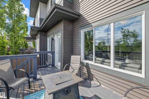 Exterior balcony featuring composite decking, painted wood railings, and direct access through a glass-paneled door - 607 40 Street, Edmonton, AB 