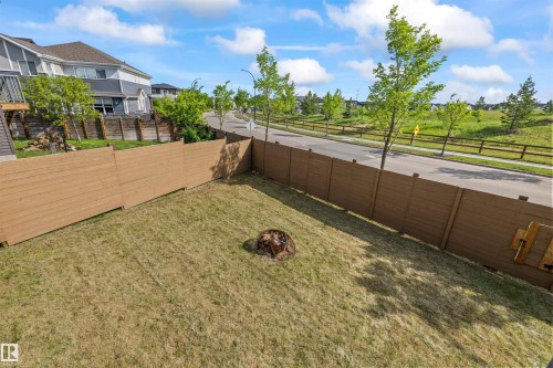 Expansive backyard featuring a manicured lawn, full perimeter privacy fencing, and a built-in fire pit - 607 40 Street, Edmonton, AB 