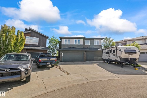 Contemporary facade with contrasting siding materials, multiple garage doors, and a concrete driveway - 607 40 Street, Edmonton, AB 