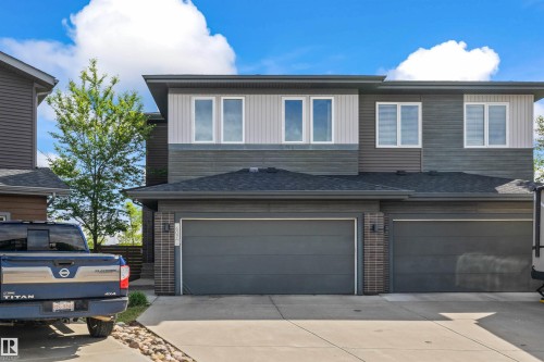 Contemporary multi-level exterior featuring multiple windows, a dual garage, and a concrete driveway - 607 40 Street, Edmonton, AB 