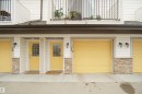 The property features white horizontal siding, yellow garage doors, and yellow entry doors with windowpanes - #13 3751 12 Street, Edmonton, AB 