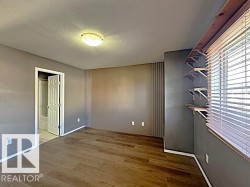 Interior space featuring wood-finish flooring and a flat-panel ceiling light fixture - 