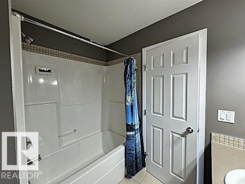 Bathtub-shower combination with a white surround and chrome fixtures - #13 3751 12 Street, Edmonton, AB 