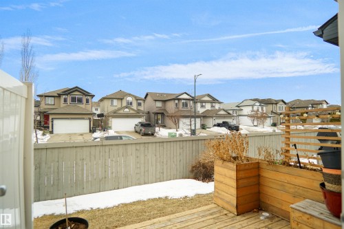 The property features a wooden deck with planter boxes, a wooden fence, and a view of residential homes - #13 3751 12 Street, Edmonton, AB 