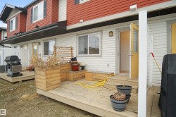 Rear exterior with a wooden deck, a wooden planter box, and a yellow door with glass panels - 