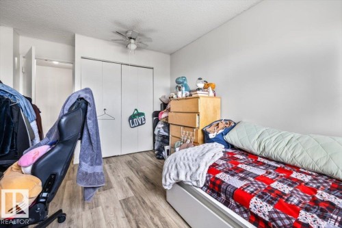 Wood-finish flooring, white walls, and a ceiling fan with integrated lighting - 77 8735 165 Street, Edmonton, AB 