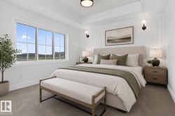 Light-filled interior featuring a large window with white muntins, tray ceiling, and wainscoting detailing - 
