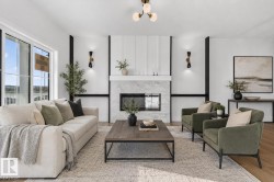Living area featuring a floor-to-ceiling fireplace with stone surround, large windows, and recessed lighting - 