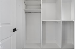 Custom closet system featuring white shelving and chrome hanging rods - 