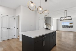 Kitchen island featuring a white countertop and dark cabinetry with silver hardware - 