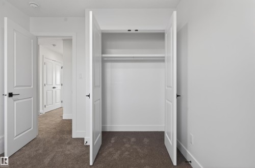 Closet featuring double bifold doors, integrated shelving, and a clothing rod - 41 River Birch Way, St. Albert, AB - Indoor Photo Showing Other Room