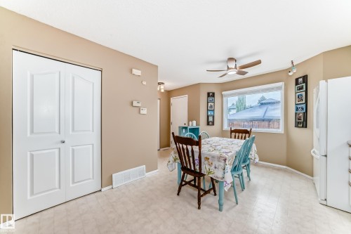 Bright dining area featuring a ceiling fan, a large window, light-colored flooring, and neutral wall tones - 11831 9 Avenue, Edmonton, AB 