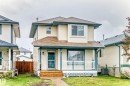 Two-story residential exterior featuring light-colored siding, a covered front porch with white railings, and a contrasting dark trim - 11831 9 Avenue, Edmonton, AB 