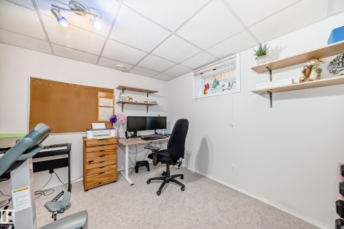 Versatile room featuring light-toned carpeting and a drop ceiling with track lighting - 11831 9 Avenue, Edmonton, AB 