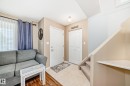 Entryway featuring a paneled door, bi-fold closet doors, and a carpeted staircase - 11831 9 Avenue, Edmonton, AB 
