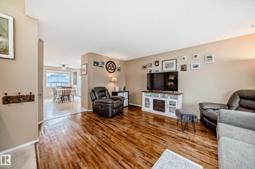 Spacious living area featuring wood-finish flooring and neutral paint - 11831 9 Avenue, Edmonton, AB 